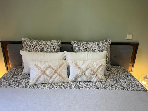 a bed with four pillows on top of it at Casa das Flores Leiria Silvercoast Portugal in Monte Redondo