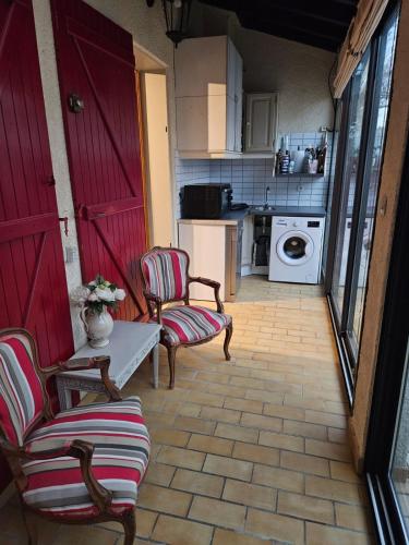 une cuisine avec deux chaises et une table et une machine à laver dans l'établissement Maison plage, à Torreilles