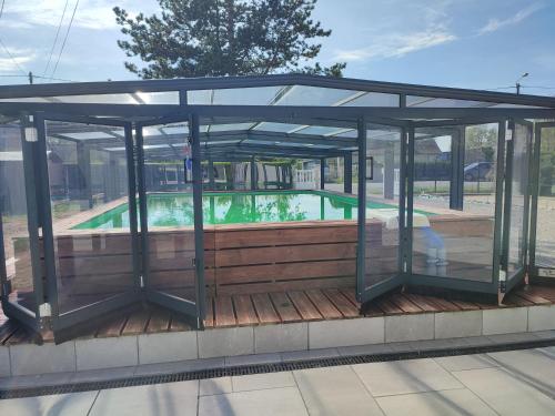 un pavillon en verre avec une piscine en arrière-plan dans l'établissement Les étoiles de la Baie, à Lanchères