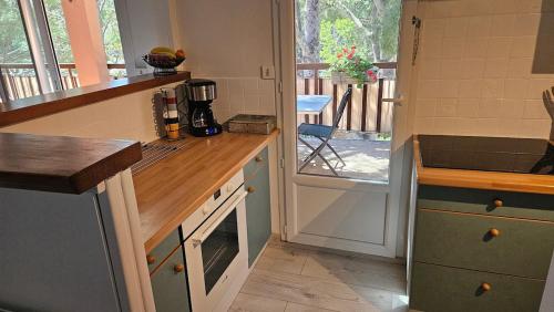 a kitchen with a counter and a table with at Appartement proche centre-ville et plages in Cavalaire-sur-Mer