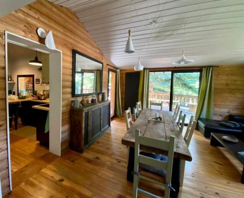 une salle à manger avec une grande table et des chaises en bois dans l'établissement La Foux d'Allos Cottage, à Allos