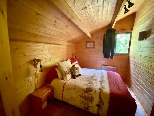 une chambre dans une cabane en rondins avec un lit dans l'établissement La Foux d'Allos Cottage, à Allos