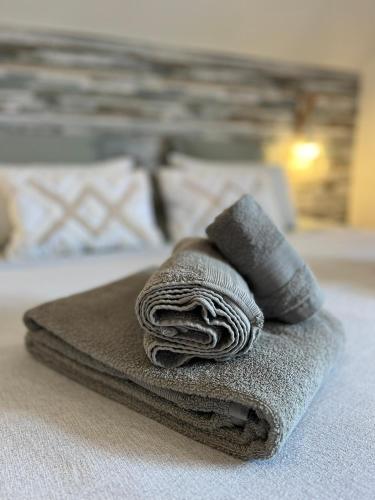 a pile of towels sitting on top of a bed at Casa das Flores Leiria Silvercoast Portugal in Monte Redondo