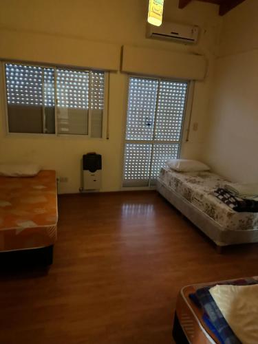 an empty room with two beds and two windows at Casa bonita de zona norte in Rosario