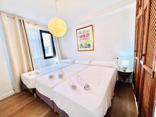 a bedroom with a large bed with white sheets at El Beaterio Apartments in Tarifa