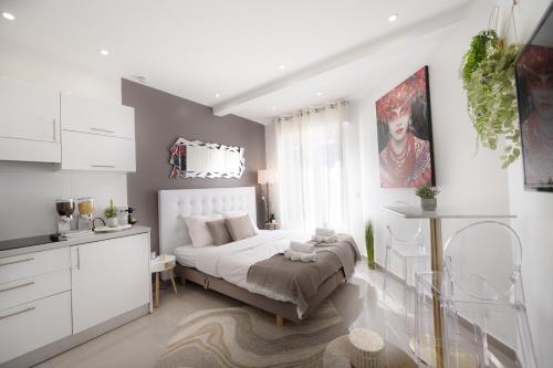 une chambre blanche avec un lit et une fenêtre dans l'établissement Le Grand Palais Studio à 3 min de la Croisette, à Cannes