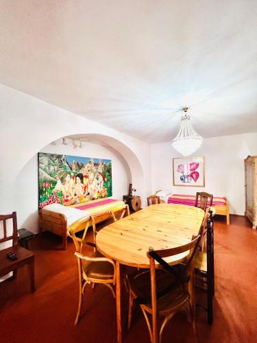 a dining room with a wooden table and a bed at El Beaterio Apartments in Tarifa