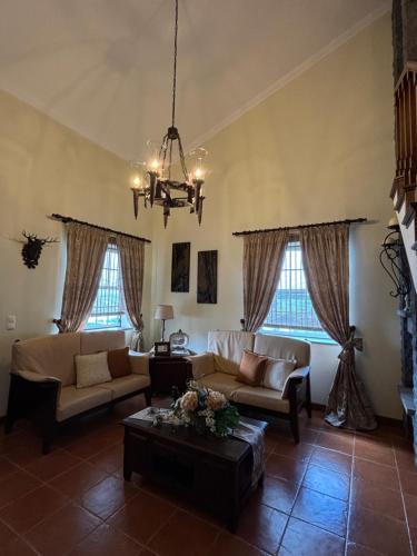 a living room with couches and a chandelier at Casa Belcanto da Fajã in Feteira