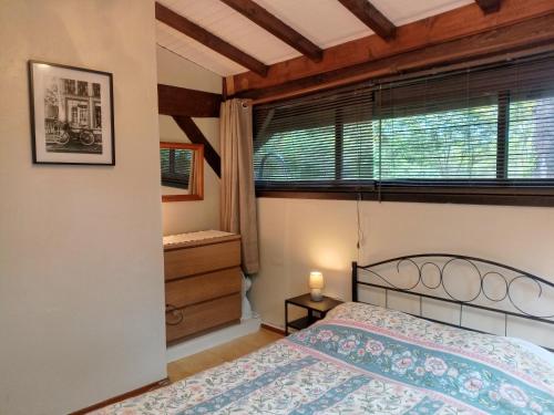a bedroom with a bed and a window at Quatre Saisons Été in Bergerac