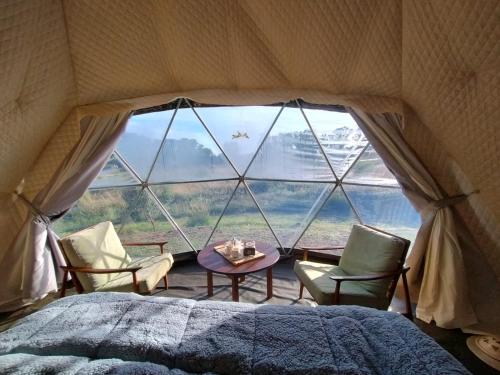 a room with a bed and two chairs and a window at LA Viella Glamp Tala in Mar del Plata