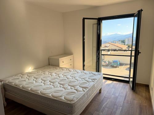 - une chambre avec un lit et une grande porte en verre dans l'établissement Charming 2-bedroom with sea and mountain views, à Bastia