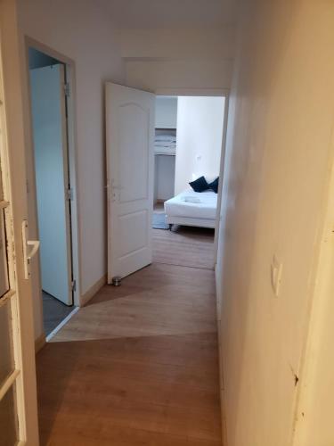 un couloir vide avec une chambre et un lit dans l'établissement Appartement F2 à Thiers, à Thiers