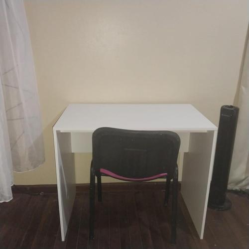a white desk with a black chair under it at Doucemaison in Tilarán