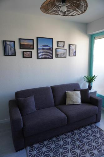 - un canapé bleu dans le salon avec plafond dans l'établissement L'Échappée lumineuse, à Cabourg