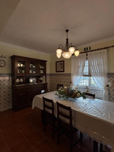 a dining room with a table with flowers on it at Casa Belcanto da Fajã in Feteira