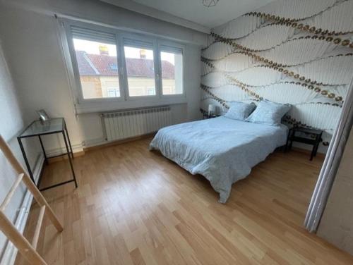 une chambre avec un lit et une grande fenêtre dans l'établissement Le Graouilly, à Metz