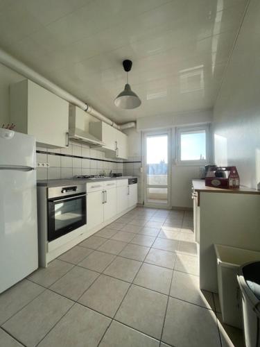 Il comprend une cuisine avec des appareils électroménagers blancs et du carrelage blanc. dans l'établissement Le Graouilly, à Metz
