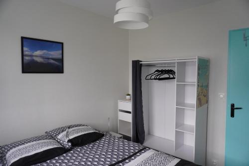 une chambre avec un lit et une étagère dans l'établissement L'Échappée lumineuse, à Cabourg