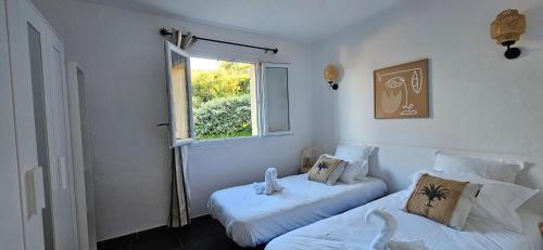 une chambre avec deux lits et une fenêtre dans l'établissement T2 Résidence Dolce & Vita C4 vue mer et piscine, à Propriano