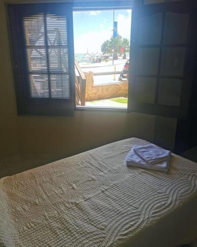 a bed in a room with a window with a towel on it at Complejo Costa Marina in Miramar