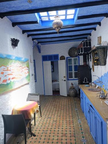 a kitchen with a blue ceiling and a table and chairs at hotel dar lalla khadouj in Chefchaouene