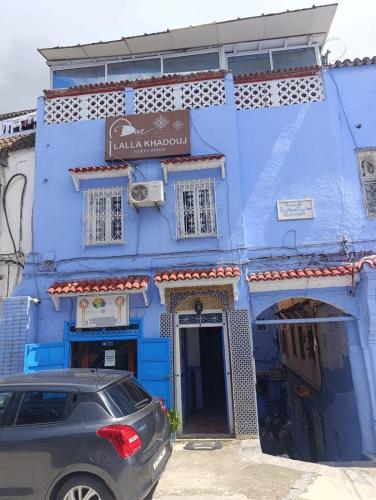 a blue building with a car parked in front of it at hotel dar lalla khadouj in Chefchaouene