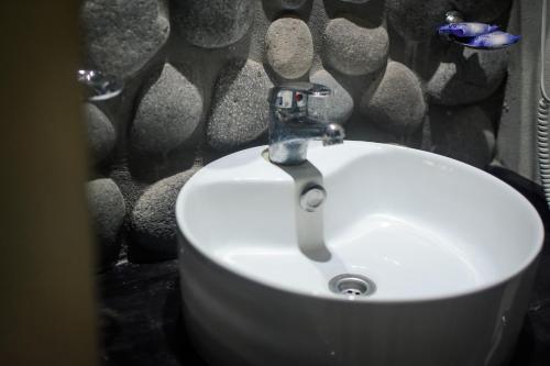a white sink in a bathroom with a stone wall at Complejo Costa Marina in Miramar
