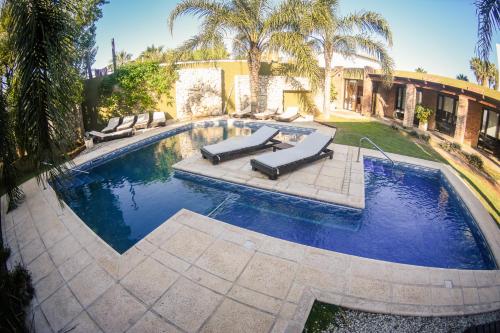 a swimming pool with two loungers in a yard at Complejo Costa Marina in Miramar