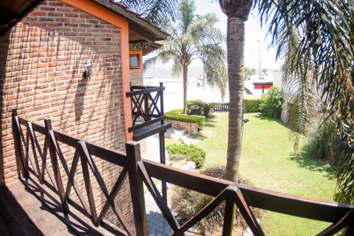 a wooden fence next to a brick building with a palm tree at Complejo Costa Marina in Miramar