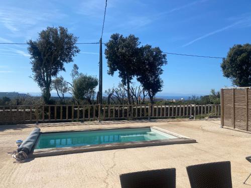 - une piscine dans une cour avec une clôture en bois dans l'établissement Petit chalet d’été avec piscine privée chauffée, à Bonifacio