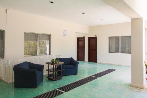 a living room with two chairs and a table at Nuevo Paris Hotel in Mérida