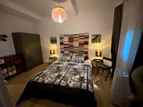 - une chambre avec un lit, deux tables et une chaise dans l'établissement Pierre's House, à Torreilles