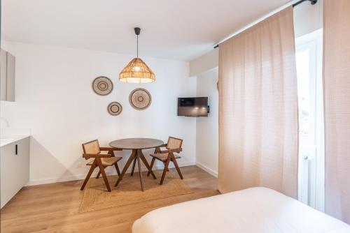 ein Esszimmer mit einem Tisch und Stühlen in einem Raum in der Unterkunft M034 Studio bohème centre ville in Annemasse