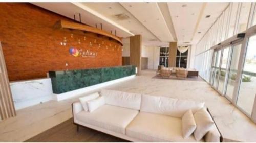 a living room with a white couch and a brick wall at Salinas Park Resort in Salinópolis