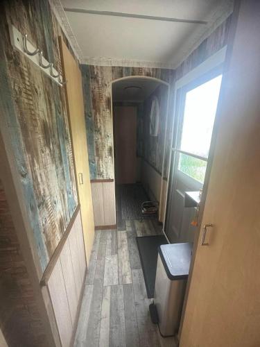a hallway with a toilet and a door to a room at Chantelle & Ashleys Caravan Getaway in Chapel Saint Leonards