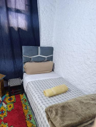 a bedroom with a bed with a pillow on it at hotel dar lalla khadouj in Chefchaouene