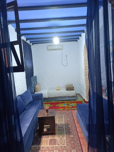 a living room with a couch and a bed at hotel dar lalla khadouj in Chefchaouene