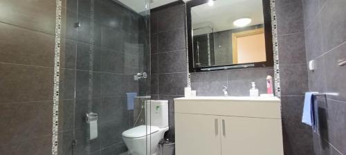 a bathroom with a toilet and a sink and a mirror at COZY Bel appartement-Wifi-Netfix-Parking in Agadir