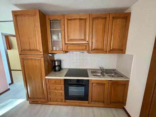 een keuken met houten kasten en een kookplaat met oven bij Villa Quattro Stagioni in Colico