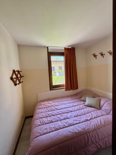 a bedroom with a purple bed with a window at Villa Quattro Stagioni in Colico