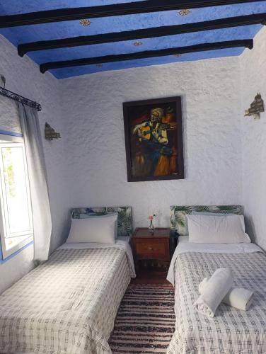 two beds in a room with a blue ceiling at hotel dar lalla khadouj in Chefchaouene
