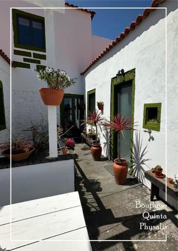 a house with potted plants on the side of it at Boutique Quinta Physalis in Fenais da Luz