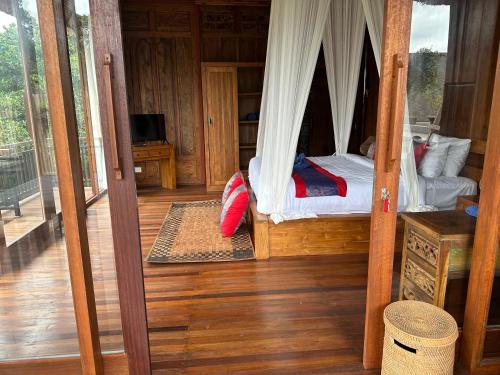 a bedroom with a canopy bed in a house at Baruna Sari Villa in Ubud