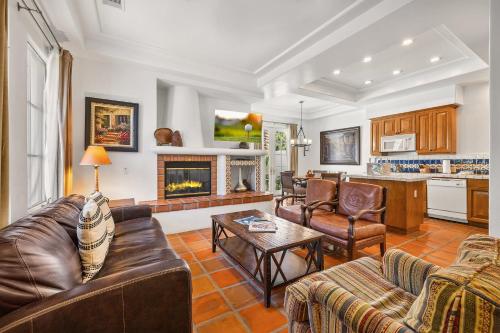 een woonkamer met lederen meubels en een open haard bij SV104 Spacious Single Story 1 Bedroom Spa Villa in La Quinta