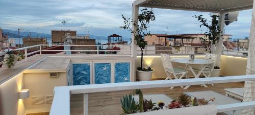 a balcony with a table and chairs on a roof at The Sorabellas in Gaeta