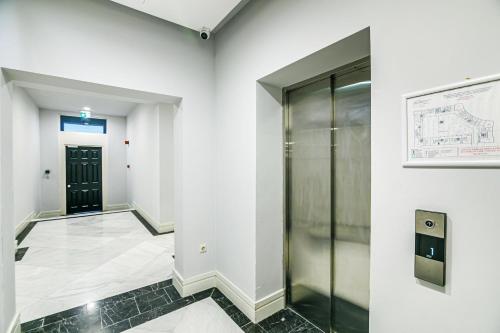 a hallway of an office with a glass elevator at Knightsbridge Apartment by Baku Housing in Baku