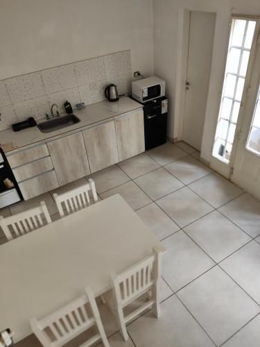 cocina con mesa, fregadero y nevera en Depto Civora 4, en Villa Regina