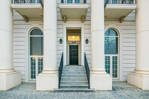 a white building with a black door and stairs at Knightsbridge Apartment by Baku Housing in Baku