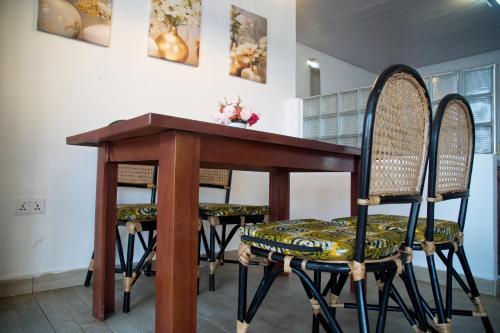 a wooden table with two chairs and a table at Atlantic View Apartment in Takoradi
