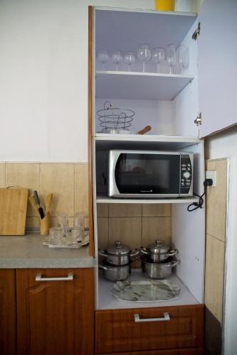 a kitchen with a microwave and some pots and pans at Atlantic View Apartment in Takoradi